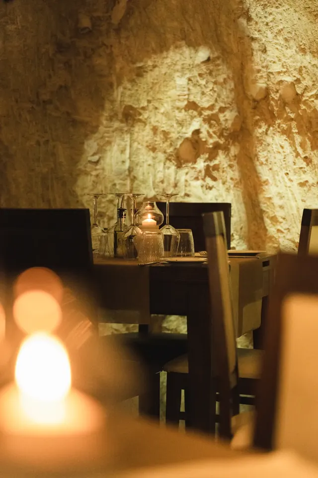 Candlelit dining table against a stone wall